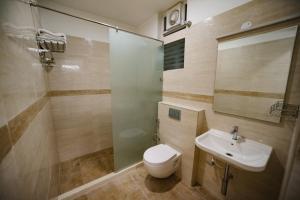 a bathroom with a toilet and a sink and a shower at Avenue 11 Premium Stays Madurai in Madurai