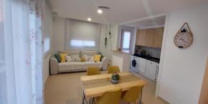 eine Küche und ein Wohnzimmer mit einem Tisch und einem Sofa in der Unterkunft Apartamento Saldonar in Vinarós