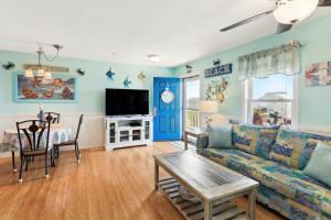 sala de estar con sofá y TV en Surf City Vacation Rental Walk to Beach!, en Surf City