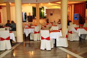 un comedor con mesas blancas y sillas blancas en Lasia Hotel, en Mytilini