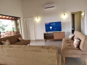 a living room with two couches and a flat screen tv at Mansion a Lago in Itauguá