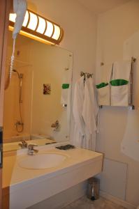 La salle de bains est pourvue d'un lavabo et d'un miroir. dans l'établissement West Hotel, à Pereslavl-Zalesski