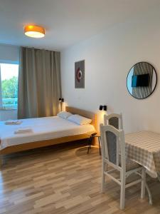 a bedroom with a bed and a table and a chair at Apart-pansion Promajna in Promajna