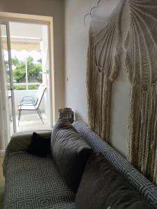 un sofá en una habitación con ventana y silla en Seaview to Olympus, sunny, cosy apartment en Néa Michanióna