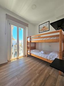 a bedroom with two bunk beds and a balcony at Apartamentos Plaza Santo Domingo in Cádiz