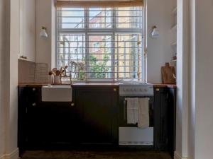 a kitchen with a stove and a sink and a window at Pass the Keys - Unique historical flat in the hart of London, South Bank in London