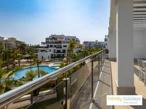 a balcony with a view of a pool and buildings at Homity Holidays - Playa Granada - Aguacate Beach in Motril