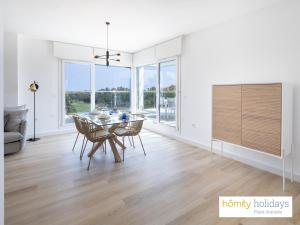 a dining room with a table and chairs in a house at Homity Exclusive Playa Granada Beach & Golf - Aguacate Beach in Motril