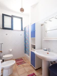 Baño blanco con aseo y lavamanos en Casa Vacanze Villa Calathatubi - Locazione turistica breve, en Alcamo Marina