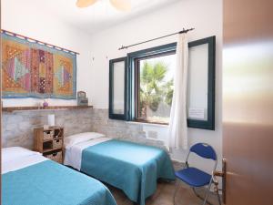 1 dormitorio con 2 camas, ventana y silla en Casa Vacanze Villa Calathatubi - Locazione turistica breve, en Alcamo Marina