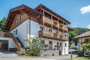 ein großes Gebäude mit Holzbalkonen darauf in der Unterkunft Aurora Moarhof Natur Apartments in Lajen