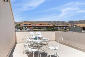 eine Terrasse mit einem Tisch und Stühlen auf dem Balkon in der Unterkunft House & Villas - Boutique Apartments in Avola