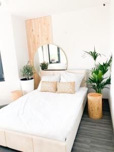 Bett in einem Schlafzimmer mit Spiegel und Pflanzen in der Unterkunft Chojno 31- dom wypoczynkowy przy jeziorze z jacuzzi in Chrostkowo