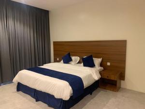 a bedroom with a large bed with a wooden headboard at اجنحة ريام in Al Namas