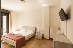 a bedroom with a bed and a flat screen tv at Casa Lungomare IX Maggio by Wonderful Italy in Bari