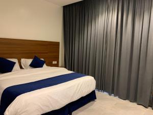 a bedroom with a large bed with black curtains at اجنحة ريام in Al Namas