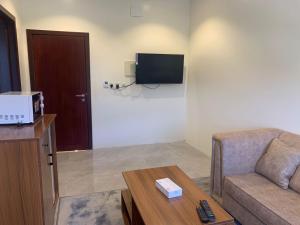 a living room with a couch and a tv at اجنحة ريام in Al Namas