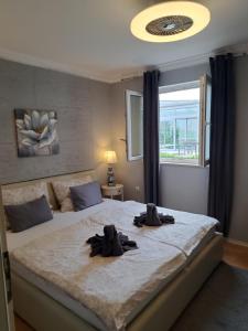 1 dormitorio con 1 cama grande con 2 guantes en Royal Apartments Sandra, en Štinjan