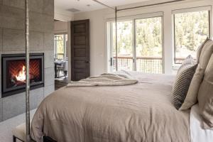 a bedroom with a bed with a fireplace at Spanish Peaks Highlands Cabin 59 in Big Sky