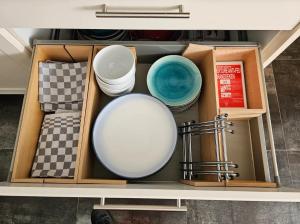 a drawer with bowls and other dishes in it at NamaStee aan Zee in Vlissingen +19 photos