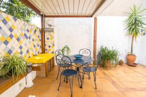 una mesa y sillas en un patio con plantas en Volets Bleus et Briques Rouges, en Albi