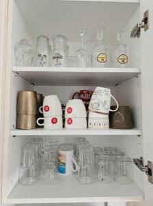 a cabinet filled with glass jars and other items at NamaStee aan Zee in Vlissingen