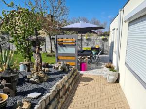 a backyard with a stone wall and an umbrella at NamaStee aan Zee in Vlissingen