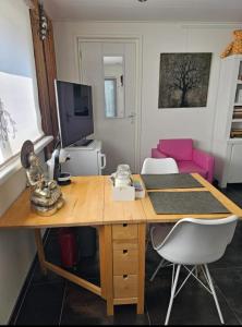 a room with a desk with a computer and a couch at NamaStee aan Zee in Vlissingen