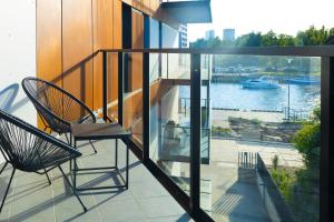 a balcony with two chairs and a view of a river at Nadmotławie Residence by HappyStay in Gdańsk