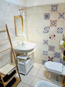 La salle de bains est pourvue d'un lavabo, de toilettes et de carrelage. dans l'établissement Casa lunae crociata, à Sarzana