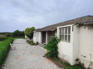 a white building with a bench next to a street at River View Resort in Bhuj