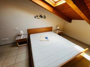 Ce lit se trouve dans un dortoir doté d'un plafond en bois. dans l'établissement Casa lunae crociata, à Sarzana