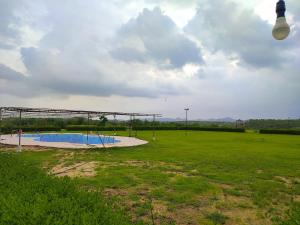 an empty park with a pool in the middle of a field at River View Resort in Bhuj