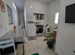 eine Küche mit einem Tisch und einem weißen Kühlschrank in der Unterkunft Chalé Conforto de Casa in Barreirinhas