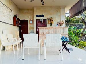 a patio with white chairs and a table at Shankara Parada Villas in Amed
