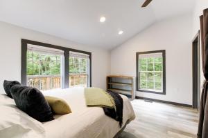 a bedroom with a large bed and two windows at Creekside Cottage in Hot Springs