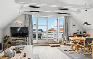 スケーエンにあるBeautiful Apartment In Skagen With Kitchenのリビングルーム(テレビ、テーブル、椅子付)