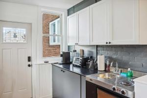 a kitchen with white cabinets and a sink at Kingston Crawfish Cottage Near Catskills! in Kingston