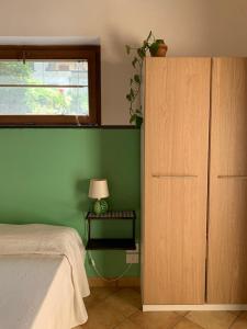 a bedroom with a bed and a green wall at La stanza in giardino in Cava deʼ Tirreni