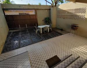 een patio met een tafel en stoelen en een hek bij Chalé Conforto de Casa in Barreirinhas