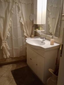een badkamer met een wastafel en een spiegel bij Nicole's home! in Nafpaktos