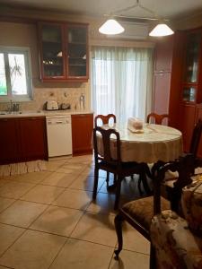 een keuken met een tafel en een tafel en stoelen bij Nicole's home! in Nafpaktos