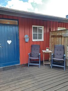 dwa krzesła siedzące na tarasie domu w obiekcie Klockestrandstugan-Höga kusten w mieście Kramfors