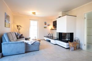 a living room with a blue couch and a fireplace at Ferienhaus Veronika an der Üselitzer Wiek in Mellnitz