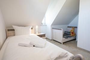 een slaapkamer met een wit bed en een trap bij Ferienhaus Veronika an der Üselitzer Wiek in Mellnitz