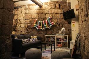 Onefam Ribeira في بورتو: غرفة معيشة مع أريكة وجدار حجري