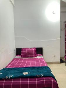 a bedroom with a pink and purple bed with purple pillows at Mohammadia Restaurant & Guest House Near United Hospital in Dhaka