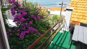 a balcony with purple flowers on a building at Apartments Lumbarda in Lumbarda