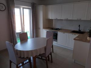 a kitchen with a table and chairs and a kitchen with a window at Apartments Lumbarda in Lumbarda