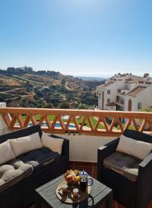 Un balcón con 2 sofás y una mesa con vistas. en Elegant apartment with fantastic views At the top of Calahonda en Sitio de Calahonda